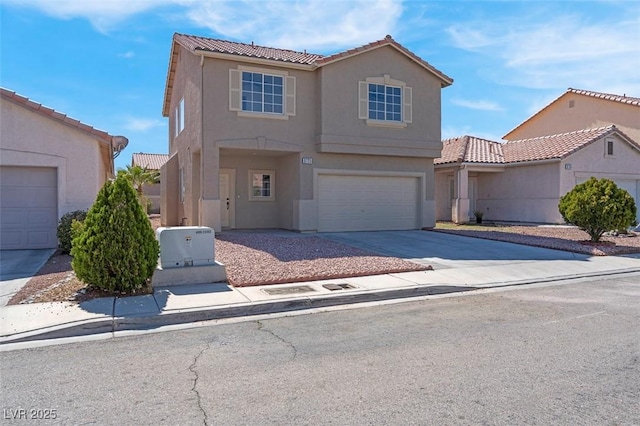 view of front facade with concrete driveway, an attached garage, a tile roof, and stucco siding