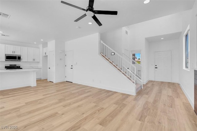 unfurnished living room featuring recessed lighting, visible vents, stairs, and light wood finished floors