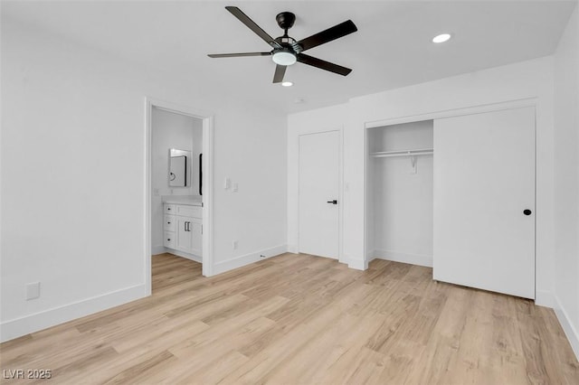 unfurnished bedroom with baseboards, ensuite bath, light wood-style flooring, recessed lighting, and a closet