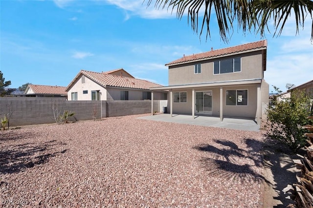 back of property with stucco siding, a fenced backyard, and a patio area