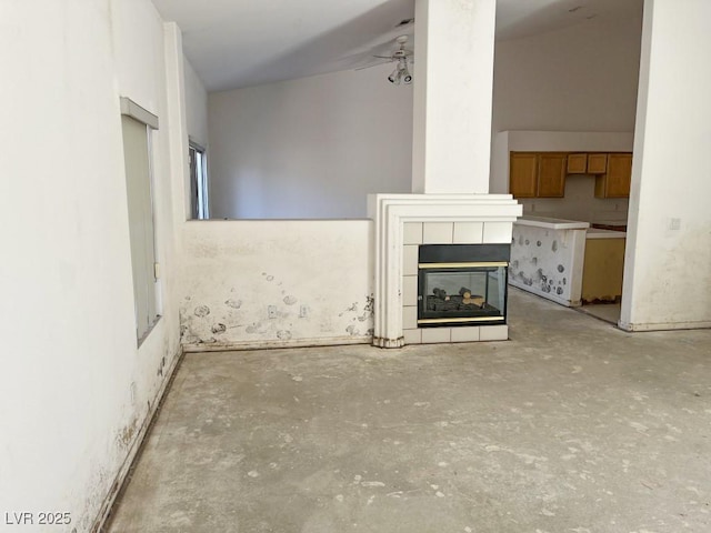 unfurnished living room featuring a ceiling fan, unfinished concrete floors, and a fireplace