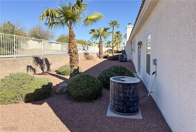 view of yard featuring central AC and fence