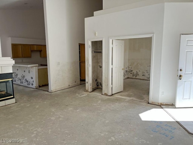 unfurnished living room featuring a fireplace and a towering ceiling