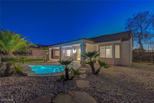 back of house featuring a patio, fence, a fenced in pool, and stucco siding