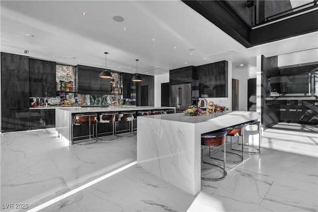 kitchen featuring marble finish floor, high quality fridge, a spacious island, and modern cabinets