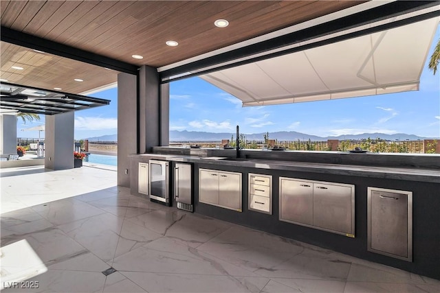 view of patio featuring a mountain view, wine cooler, and area for grilling