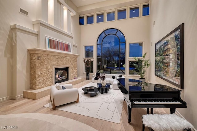 9801 Orient Express Ct, Las Vegas, NV 89145 - living area with a high ceiling, baseboards, wood finished floors, a tile fireplace, and visible vents