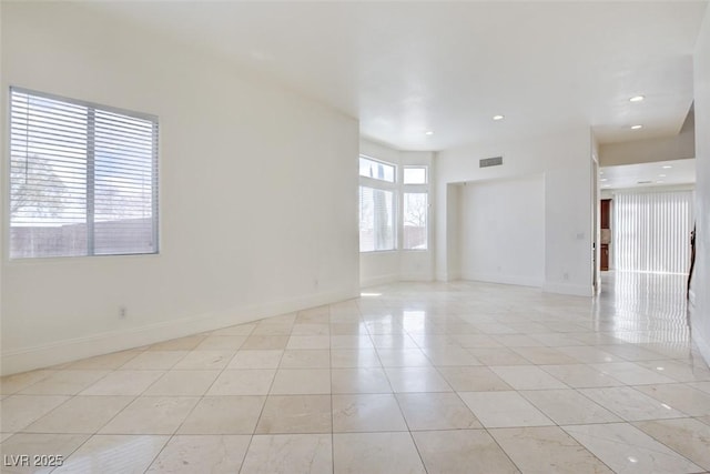 spare room featuring light tile patterned floors, visible vents, and baseboards