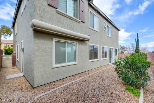 view of side of property with stucco siding and a fenced backyard