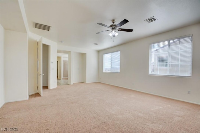 unfurnished room featuring visible vents, light colored carpet, and ceiling fan