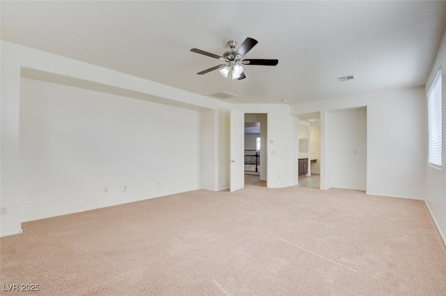 unfurnished room featuring light colored carpet, visible vents, and ceiling fan