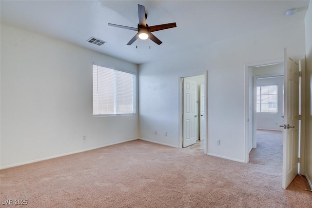 unfurnished bedroom featuring light carpet, visible vents, ceiling fan, and baseboards