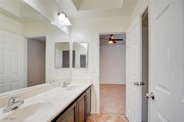 bathroom with double vanity, tile patterned floors, a raised ceiling, and a sink