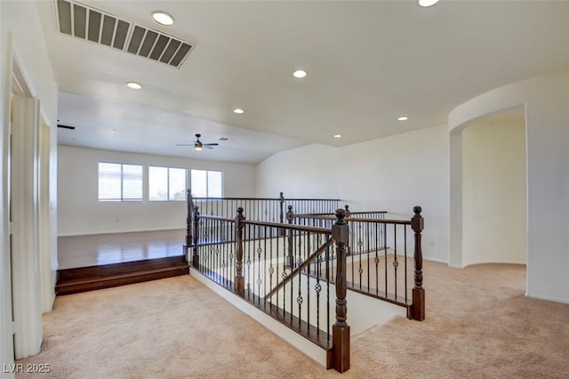 empty room featuring arched walkways, visible vents, recessed lighting, and carpet floors