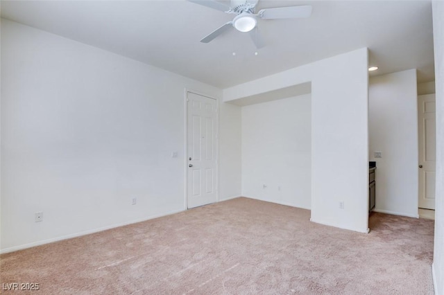 spare room featuring light colored carpet and ceiling fan