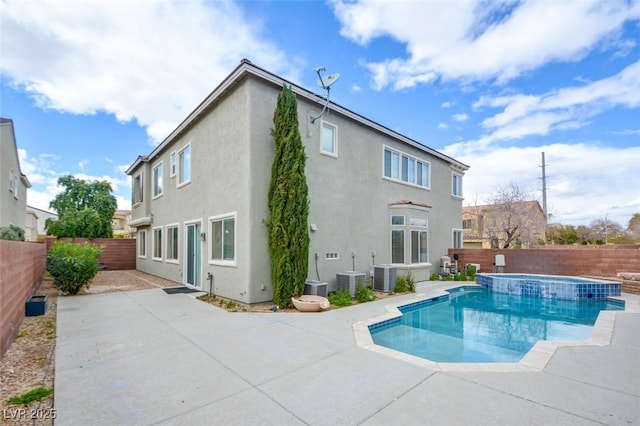 rear view of house with a patio area, central air condition unit, a fenced backyard, and stucco siding