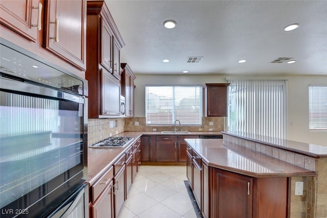 kitchen featuring stainless steel gas cooktop, visible vents, and tasteful backsplash