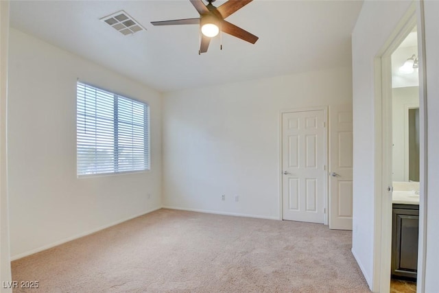 carpeted spare room with a ceiling fan, visible vents, and baseboards