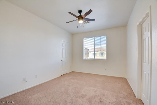 unfurnished room with ceiling fan, baseboards, and light carpet