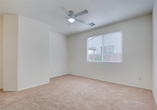 unfurnished room with a ceiling fan, visible vents, carpet floors, and baseboards