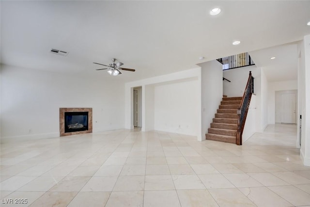 unfurnished living room with visible vents, a ceiling fan, recessed lighting, stairs, and a tile fireplace