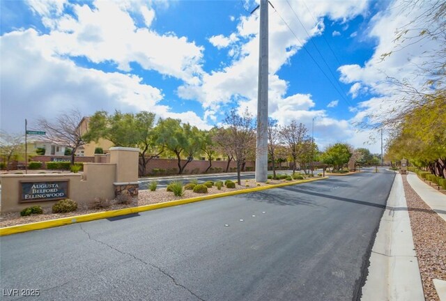 view of road with a gated entry and curbs