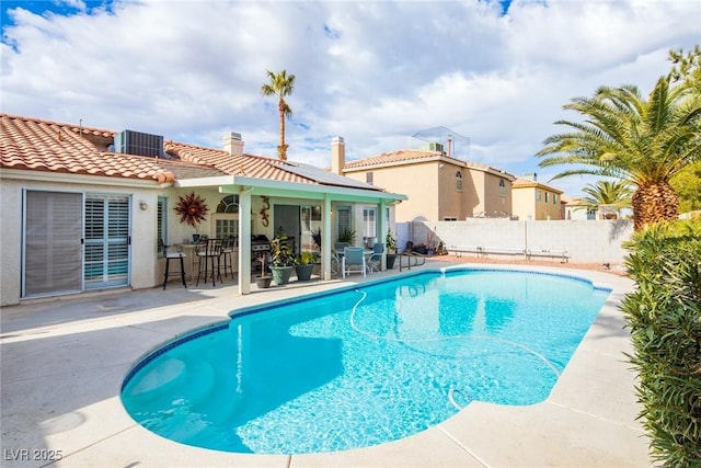 view of pool with outdoor dry bar, a fenced in pool, central AC, a fenced backyard, and a patio area