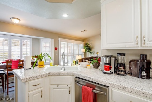 kitchen featuring a sink, plenty of natural light, stainless steel dishwasher, and white cabinetry