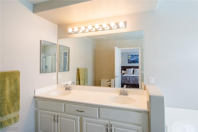 full bath featuring ensuite bath, double vanity, toilet, and a sink