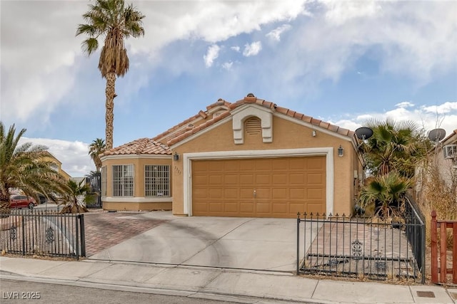 mediterranean / spanish-style house featuring stucco siding, a tiled roof, concrete driveway, and fence