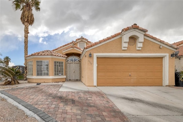 mediterranean / spanish home featuring a tile roof, stucco siding, driveway, and an attached garage