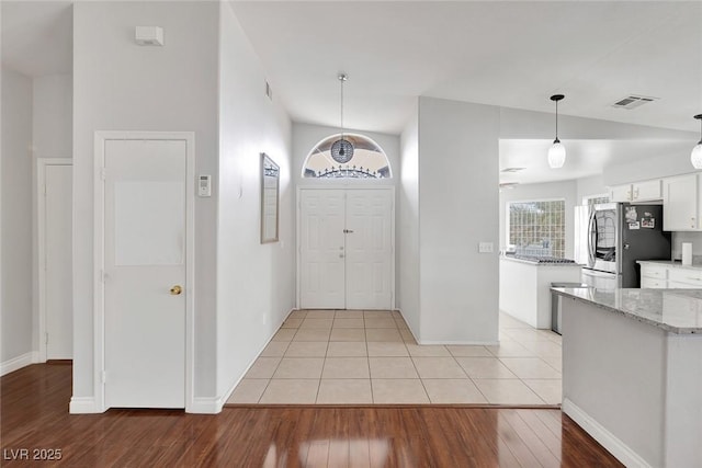 entryway featuring visible vents, baseboards, and light wood-style floors