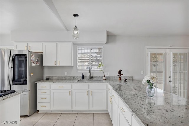 kitchen featuring a sink, white cabinets, refrigerator with glass door, and light tile patterned floors