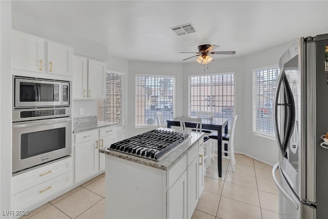 kitchen featuring light tile patterned floors, visible vents, a healthy amount of sunlight, and appliances with stainless steel finishes