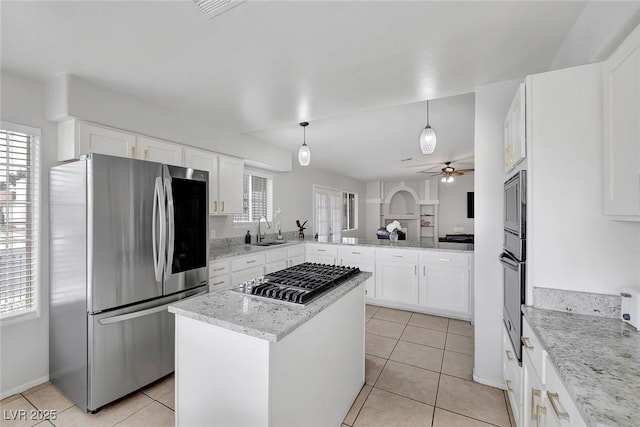 kitchen featuring white cabinets, light tile patterned floors, appliances with stainless steel finishes, and a sink