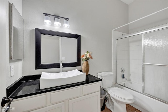 full bathroom featuring enclosed tub / shower combo, toilet, and vanity