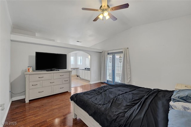 bedroom featuring wood finished floors, visible vents, lofted ceiling, arched walkways, and french doors