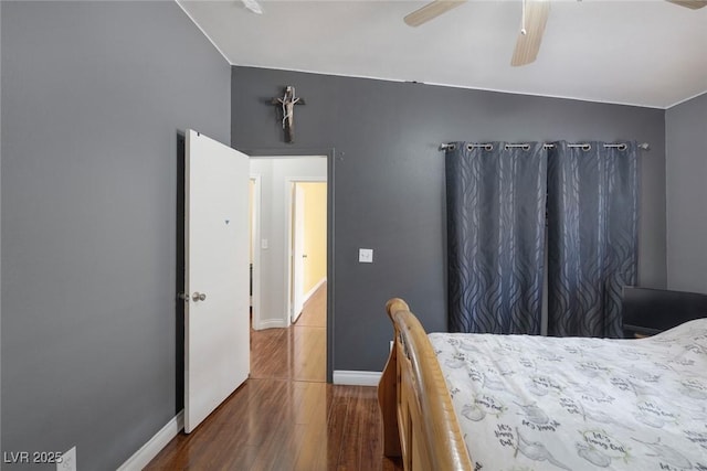 bedroom with ceiling fan, dark wood-type flooring, baseboards, and vaulted ceiling