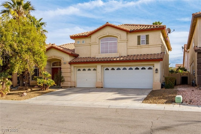 mediterranean / spanish home featuring concrete driveway, a tiled roof, a garage, and stucco siding