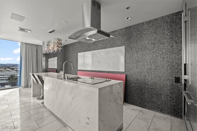 kitchen with visible vents, island exhaust hood, expansive windows, black electric cooktop, and marble finish floor