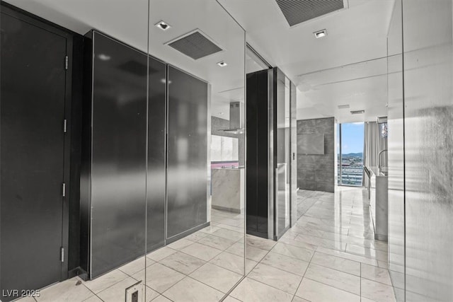 bathroom with a wall of windows and visible vents