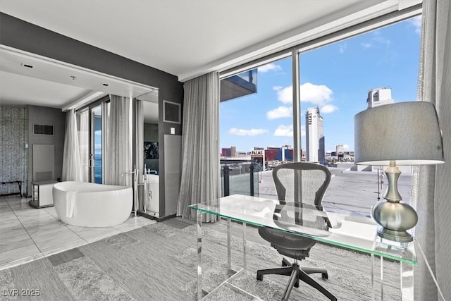 office space with visible vents, a view of city, and a wall of windows