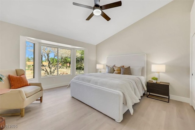 bedroom with vaulted ceiling, light wood-style flooring, baseboards, and ceiling fan