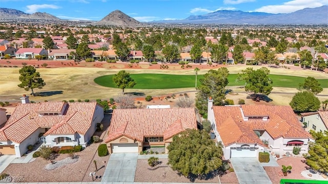 aerial view with view of golf course, a mountain view, and a residential view