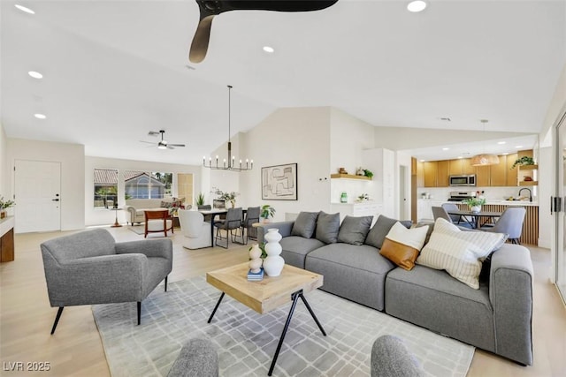 living room with recessed lighting, light wood-style flooring, vaulted ceiling, and ceiling fan with notable chandelier