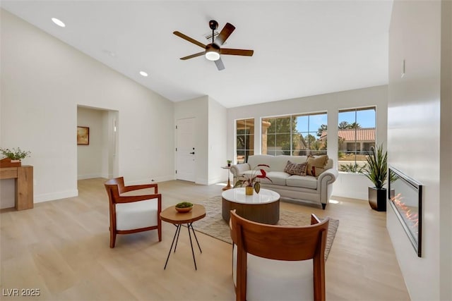 living room featuring baseboards, ceiling fan, light wood-type flooring, recessed lighting, and high vaulted ceiling