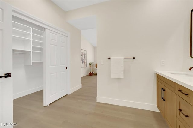 bathroom with vanity, baseboards, and wood finished floors