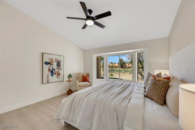 bedroom with baseboards, lofted ceiling, a ceiling fan, and light wood finished floors