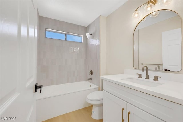 bathroom featuring wood finished floors, toilet, bathtub / shower combination, and vanity