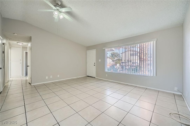 empty room featuring baseboards, lofted ceiling, light tile patterned floors, a textured ceiling, and a ceiling fan